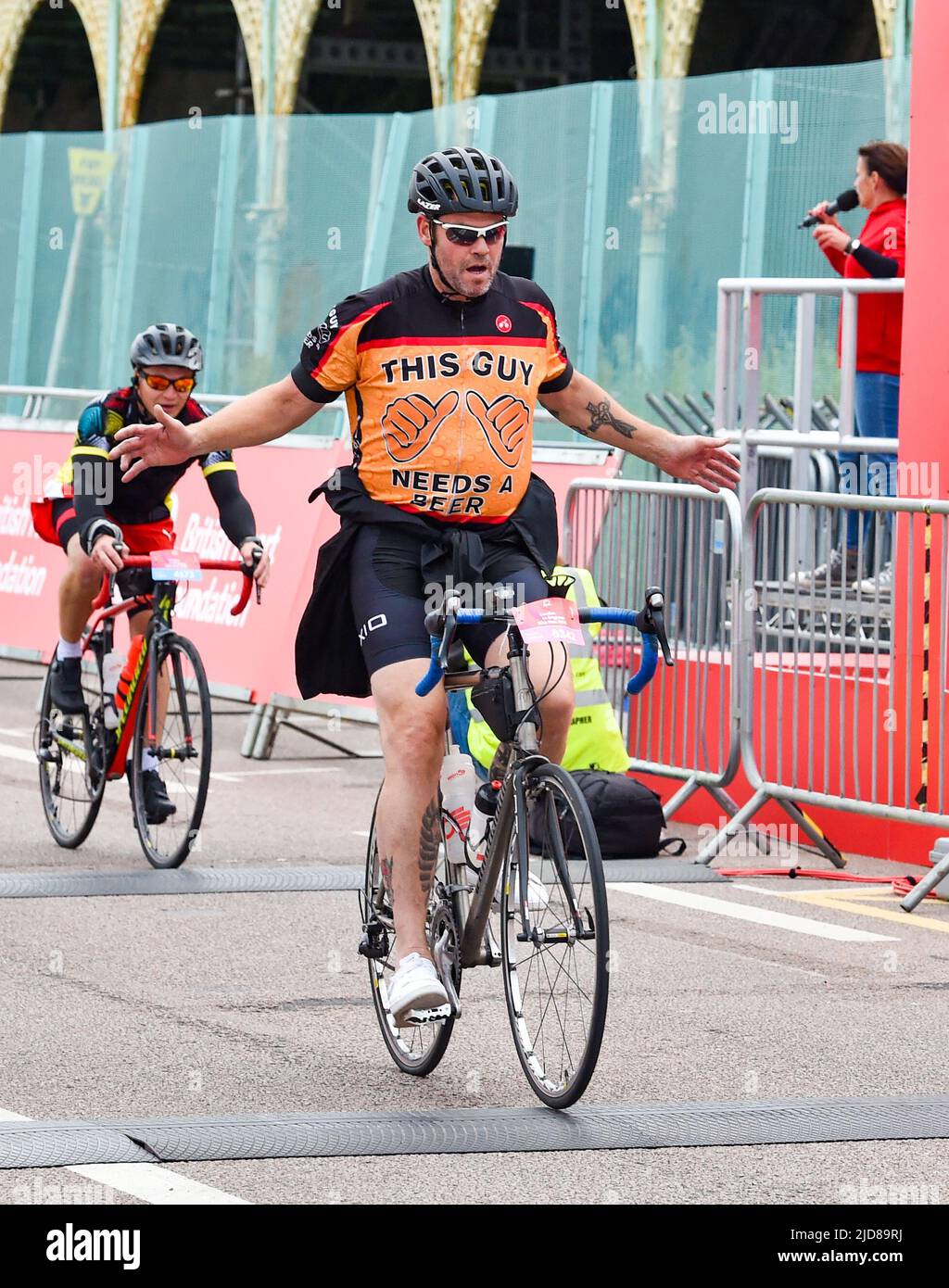 Brighton UK 19th June 2022 - Cyclists head over the finish line after taking part in the London to Brighton Bike Ride in aid of the British Heart Foundation on a much cooler day than it has been recently : Credit Simon Dack / Alamy Live News Stock Photo