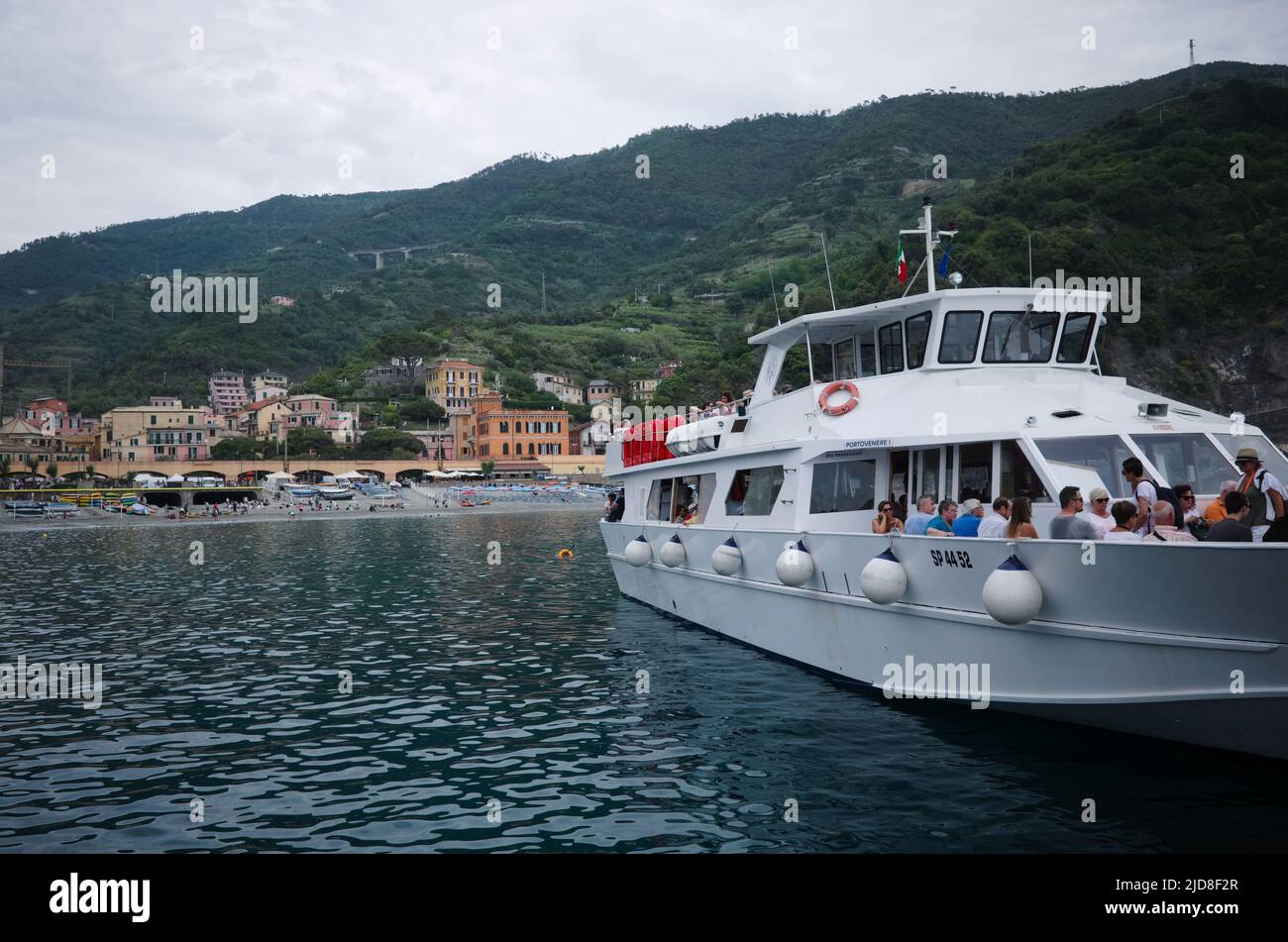Monterosso, Liguria, Italy - May, 2022: Passenger ferry boat with tourists on board is moored in bay of Mediterranean in Cinque terre national park Stock Photo