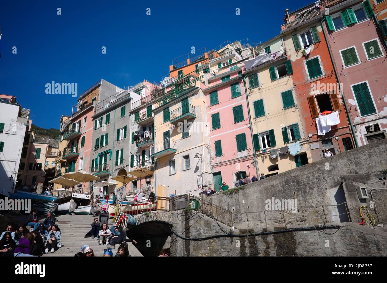 Riomaggiore, Liguria, Italy - April, 2022: Traditional Mediterranean Italian residential buildings with weathered colorful facades Stock Photo