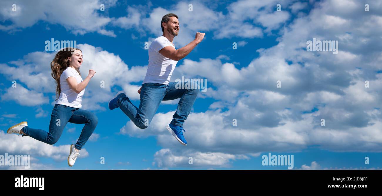 Father and daughter jump on sky, banner with copy space. father and daughter jump high. hurry up. happy childhood and fatherhood. concept of Stock Photo