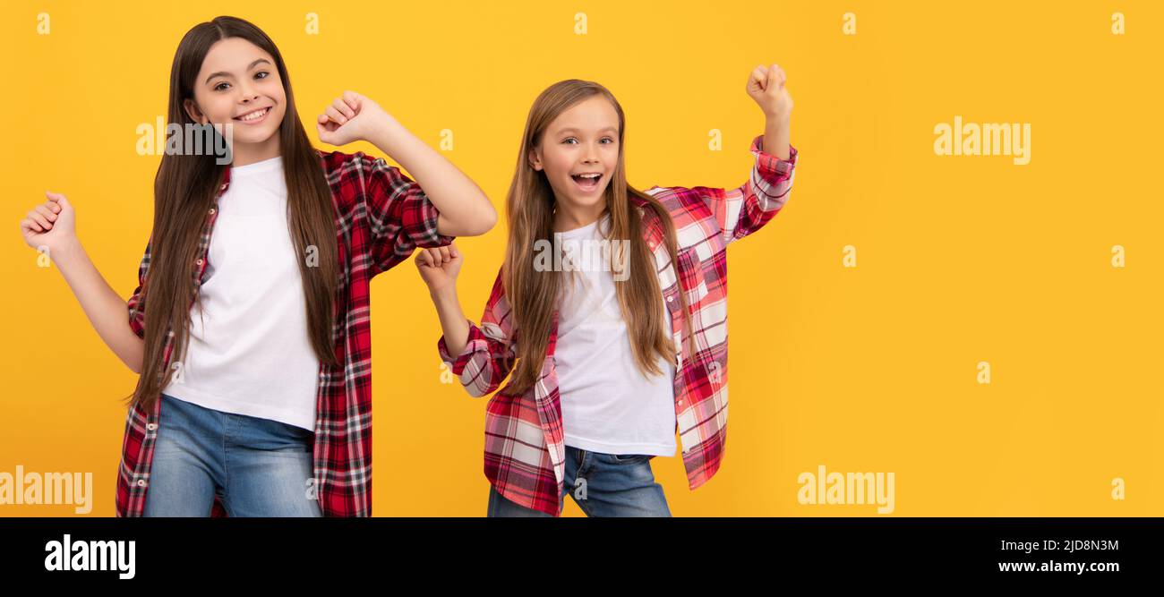 Girl friends. happy kids in casual checkered shirt having fun on yellow background, friendship. Casual teen children friends horizontal poster. Banner Stock Photo