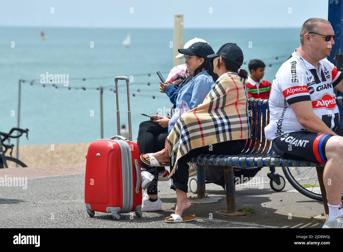 Brighton UK 19th June 2022 - Visitors wrapped up in warm clothing on Brighton seafront at lunchtime today as cooler weather spreads across Britain after the recent hot spell .   : Credit Simon Dack / Alamy Live News Stock Photo