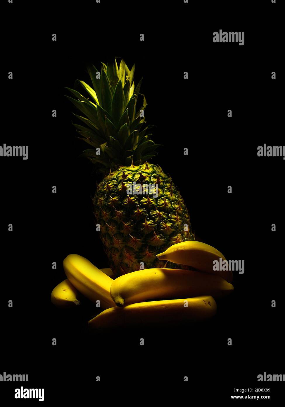 Dessert ready, a pineapple and five banana all together, nicely place in a black background