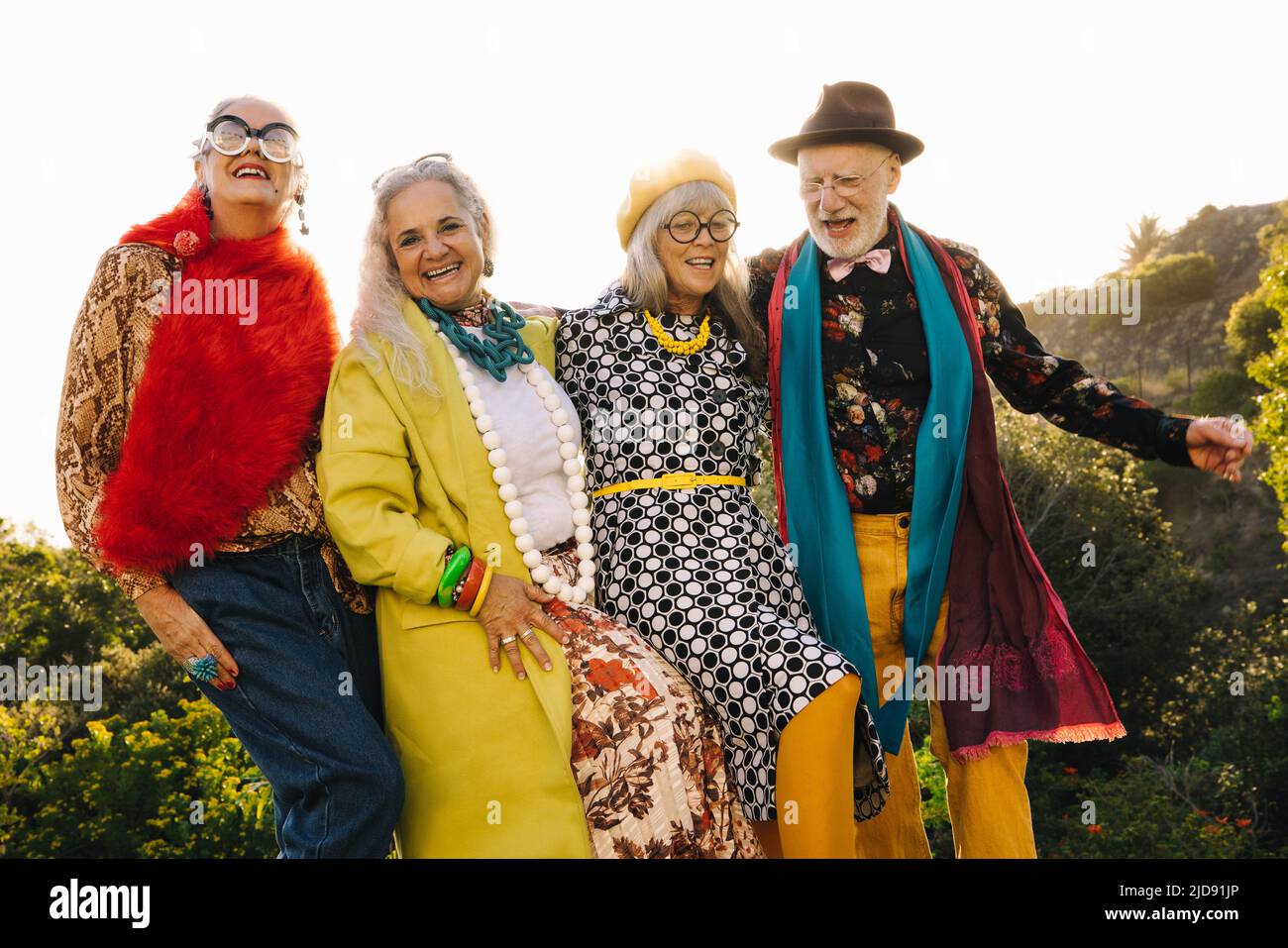 Senior citizens having fun while standing together in a park. Group of cheerful senior friends wearing colourful casual clothing. Carefree elderly peo Stock Photo