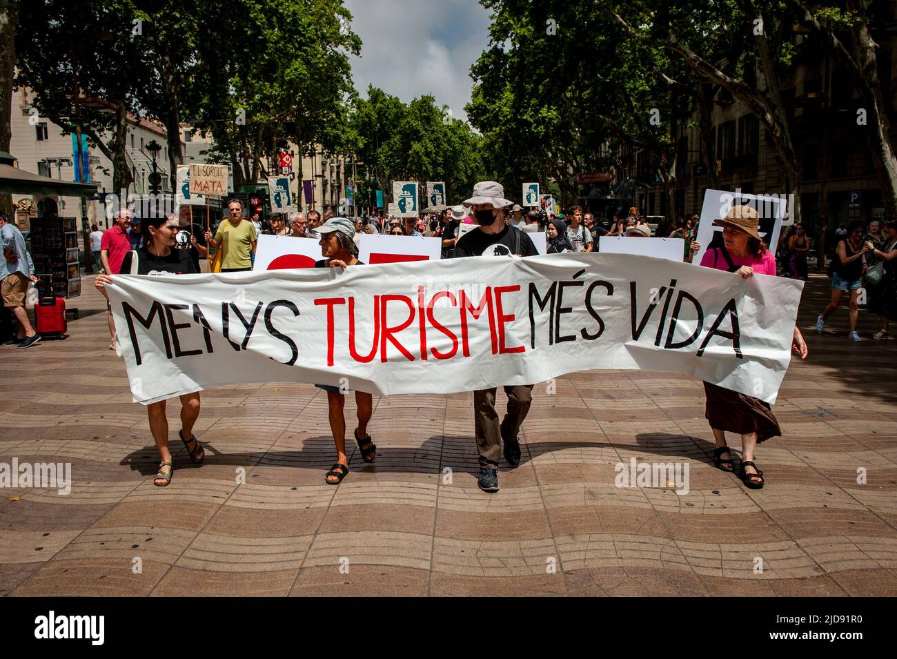 Barcelona residents march in La Rambla carrying a banner that reads 'Less Tourism, more life' during a protest against mass tourism in the city. Stock Photo