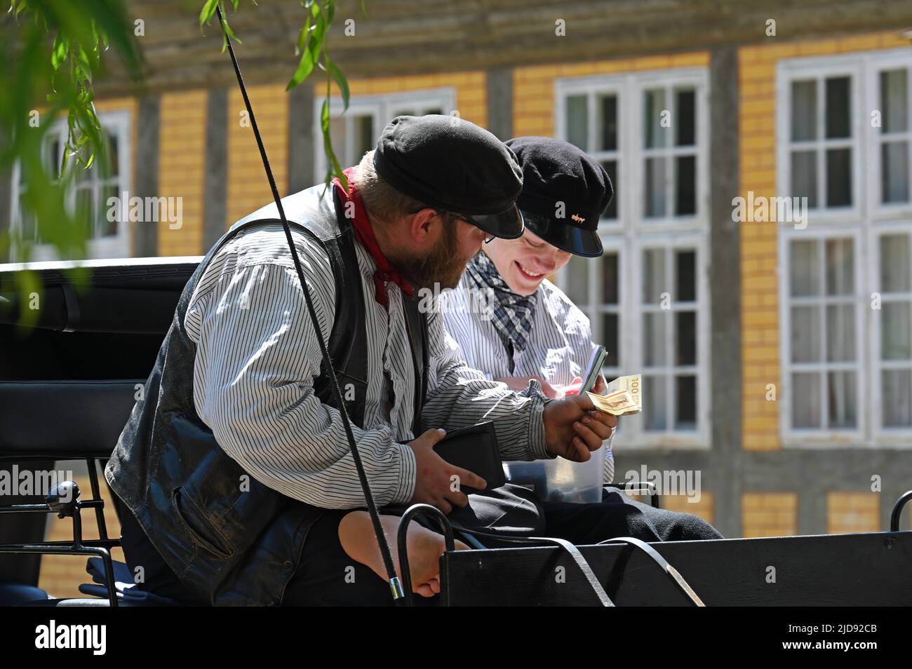 Two coachmen are happy about a banknote they have taken Stock Photo