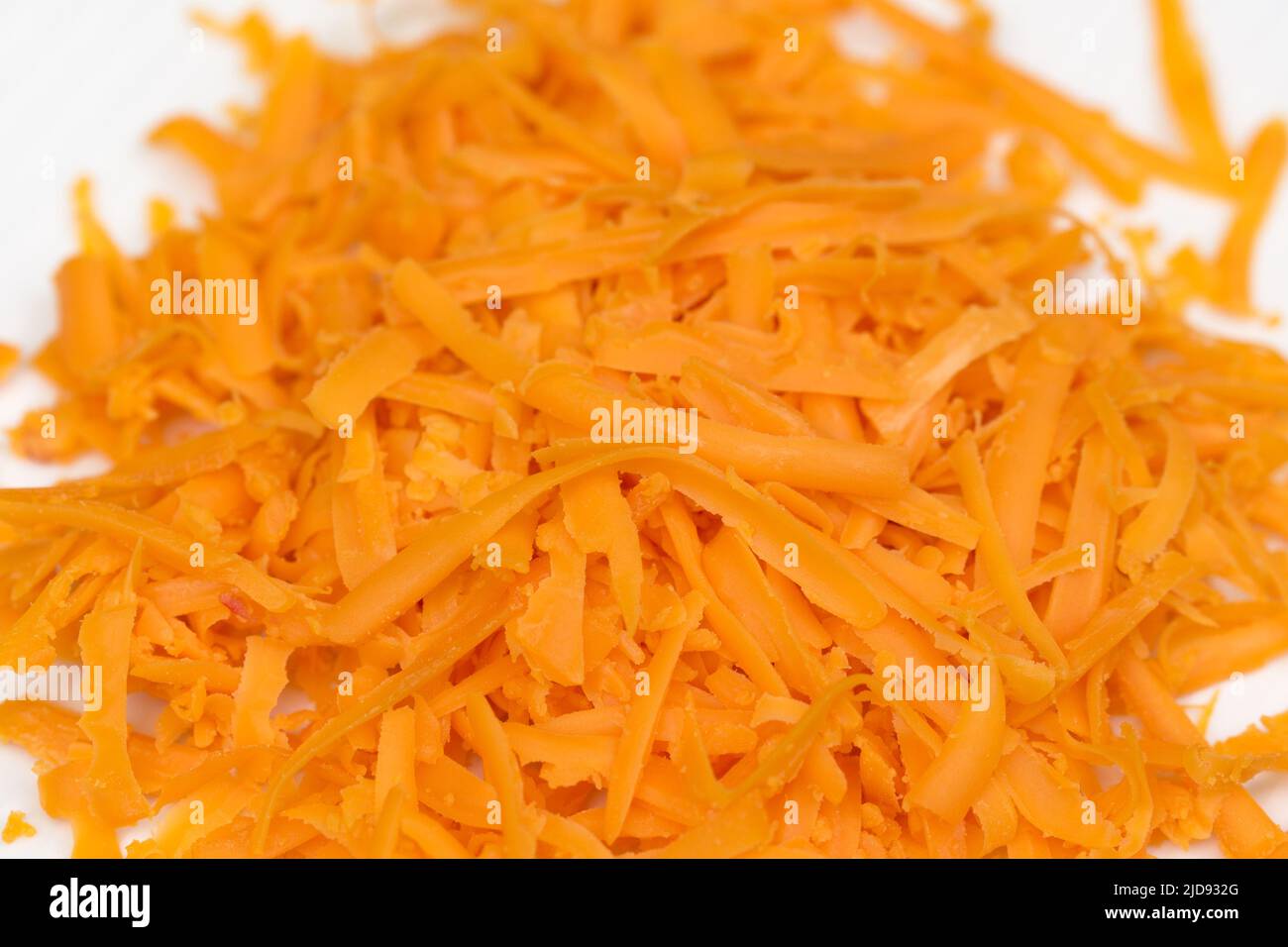 grated mimolette cheese on plate closeup selective focus Stock Photo