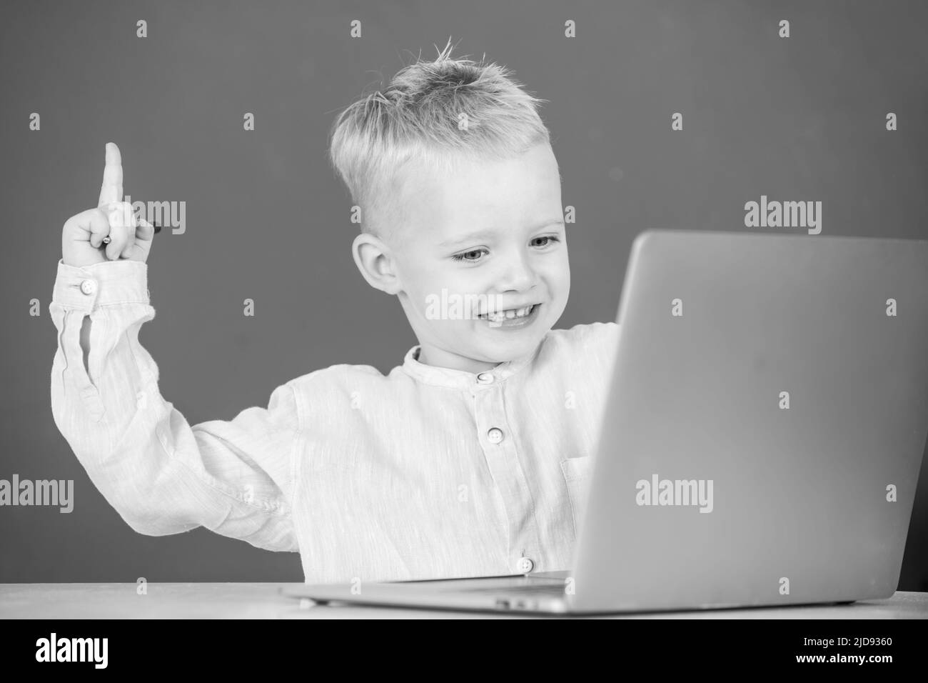 Amazed child using gadgets to study. Computer education for kids. Genius child programming, computer training. Stock Photo