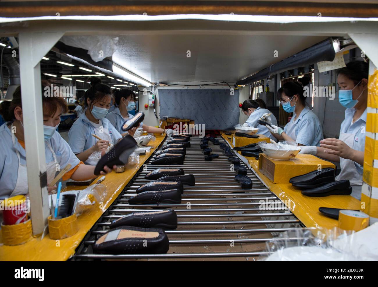 HUAI'AN, CHINA - JUNE 17, 2022 - Workers work on a production line at Huating Shoes Co., LTD in Huai'an, East China's Jiangsu Province, June 17, 2022. Stock Photo