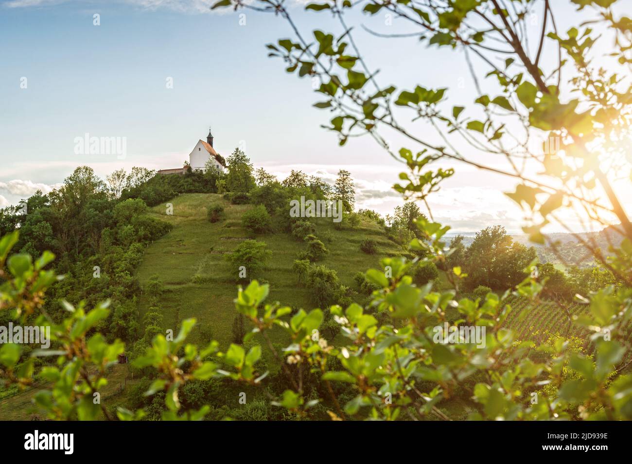 Lonely, picturesque chapel (Wurmlinger Kapelle) on a steep hill at sunset in Southern Germany Stock Photo