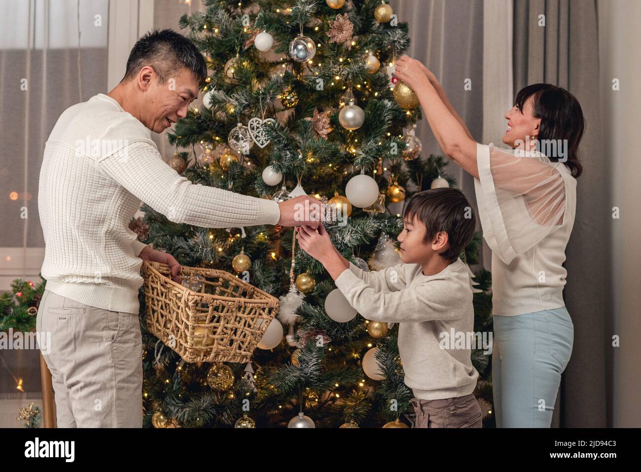 Happy family decorating christmas tree together Stock Photo
