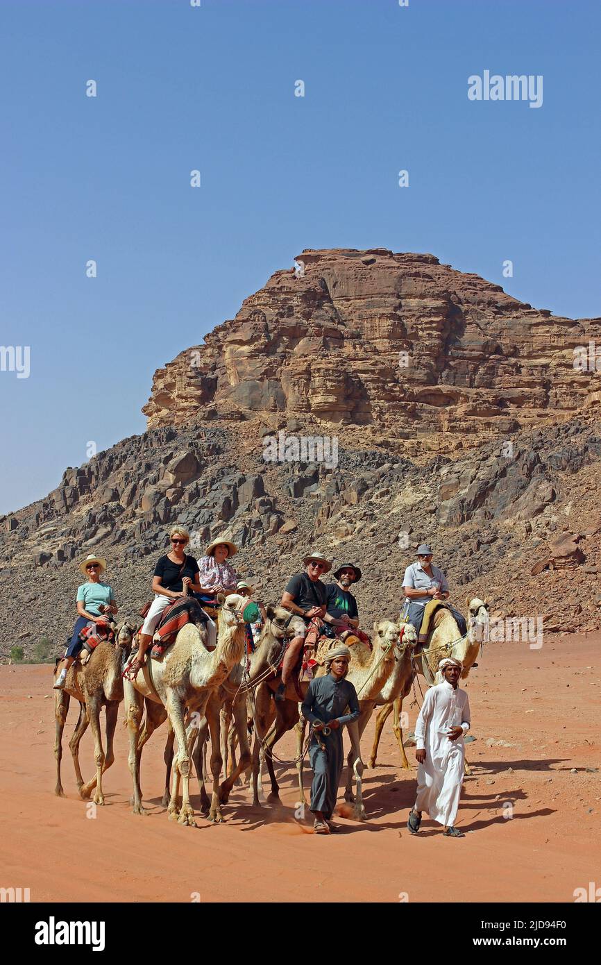 Tourists Riding Camels in Wadi Rum, Jordan Stock Photo