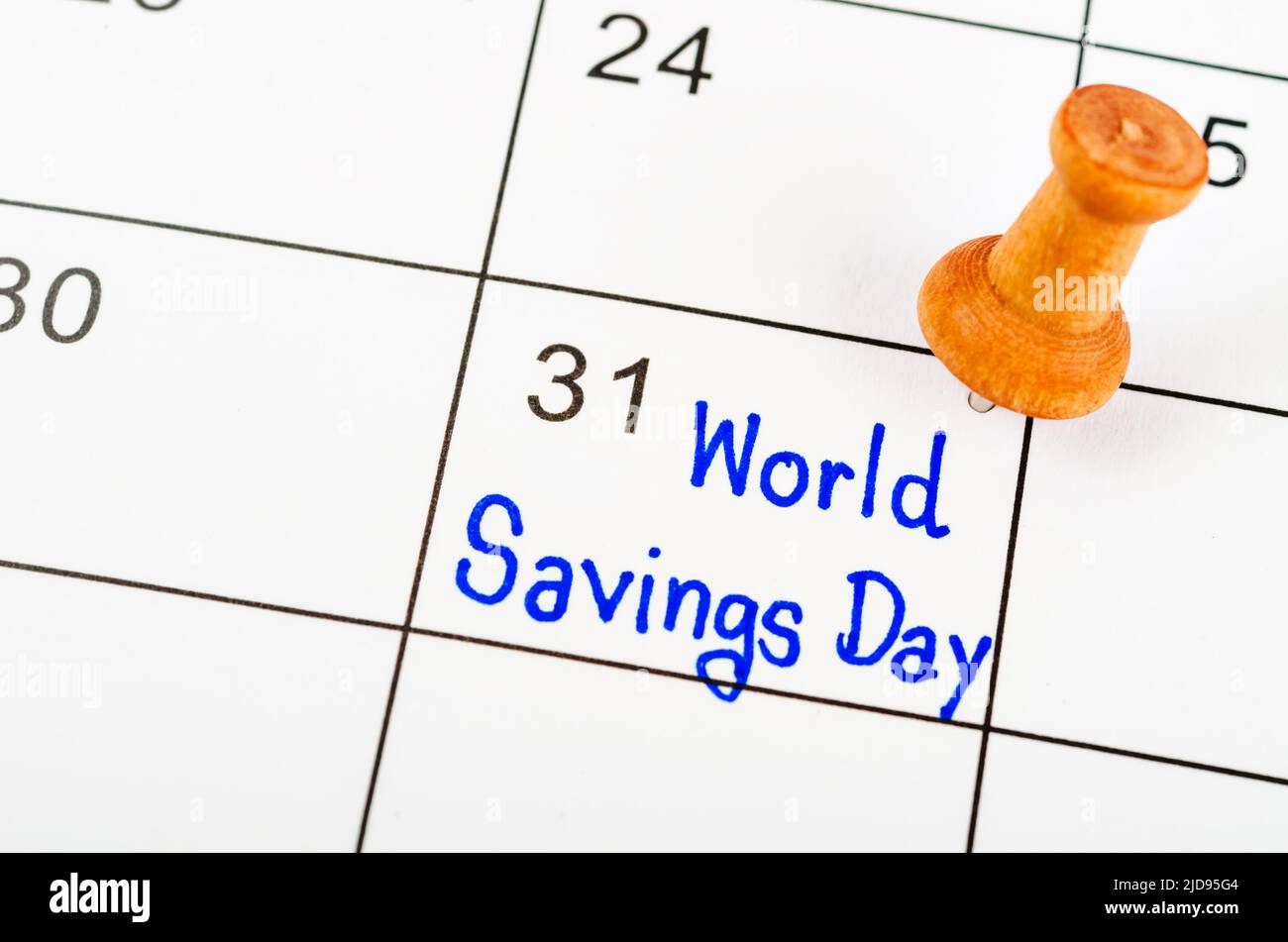 The Handwritten World savings day marked with wooden pin on a white