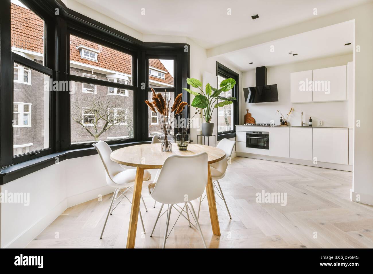 Contemporary open plan kitchen with dining table set and gray sofa in