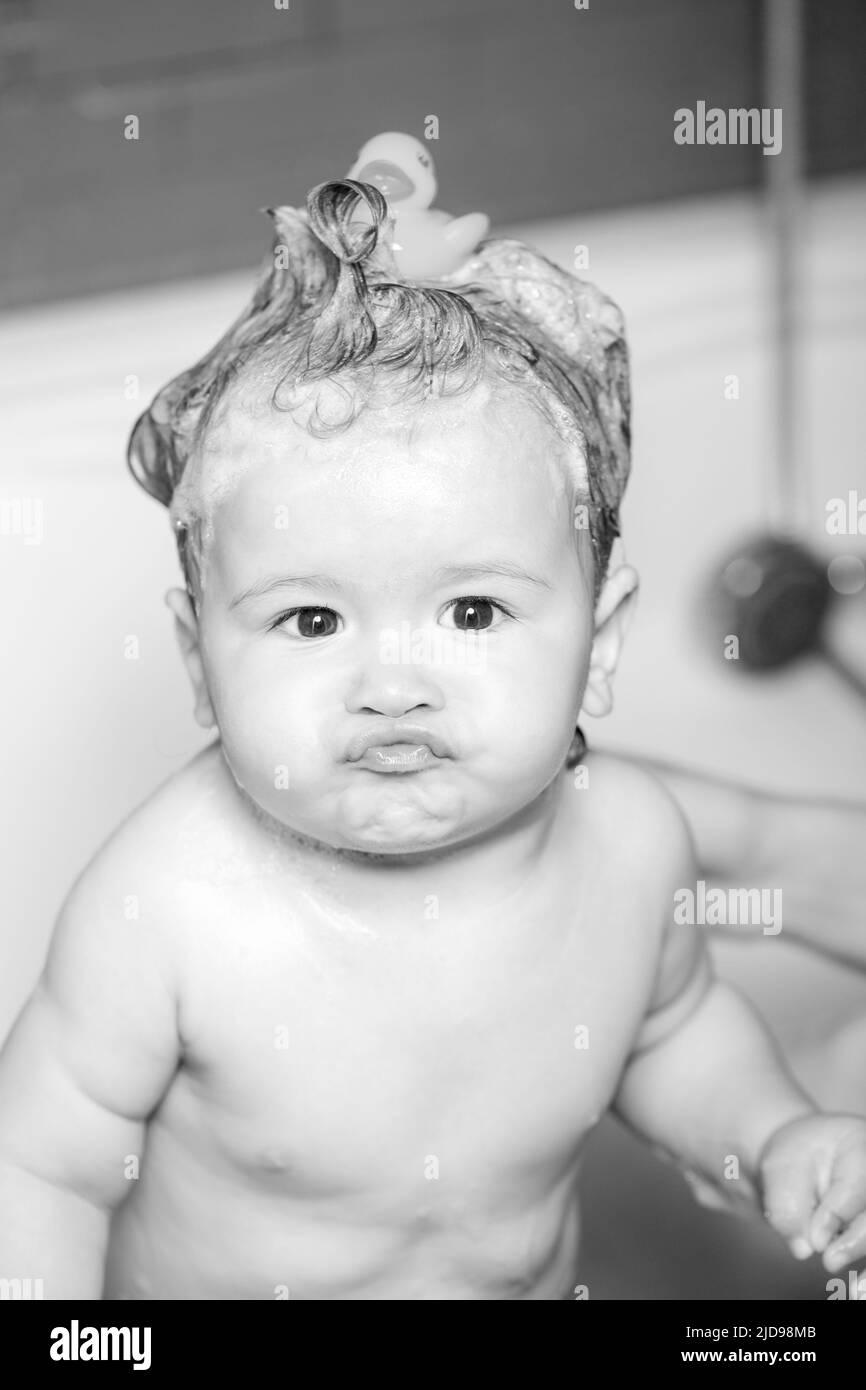 Kid bathing in bathroom. Funny Baby showering. Portrait of fun kid