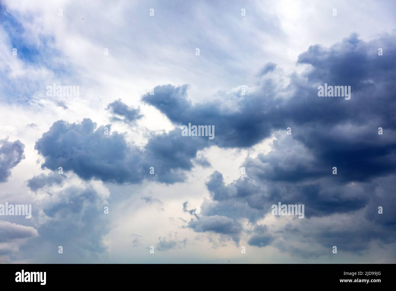 Heavy dark cloud on blue sky background, Fluffy cumulus clouds, cloudscape white and grey color,  gloomy weather Stock Photo