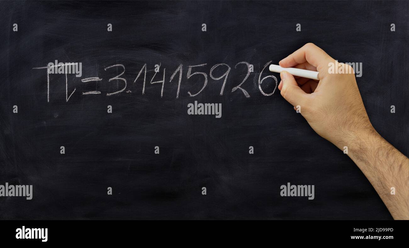 Pi number, mathematical constant chalk drawing on a school black board, Male hand write decimal digits with a chalk Stock Photo