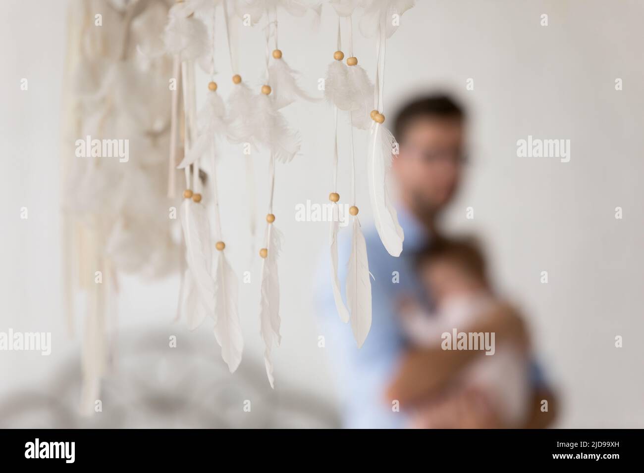 Closeup dreamcatcher, father and baby in his arms on background Stock Photo