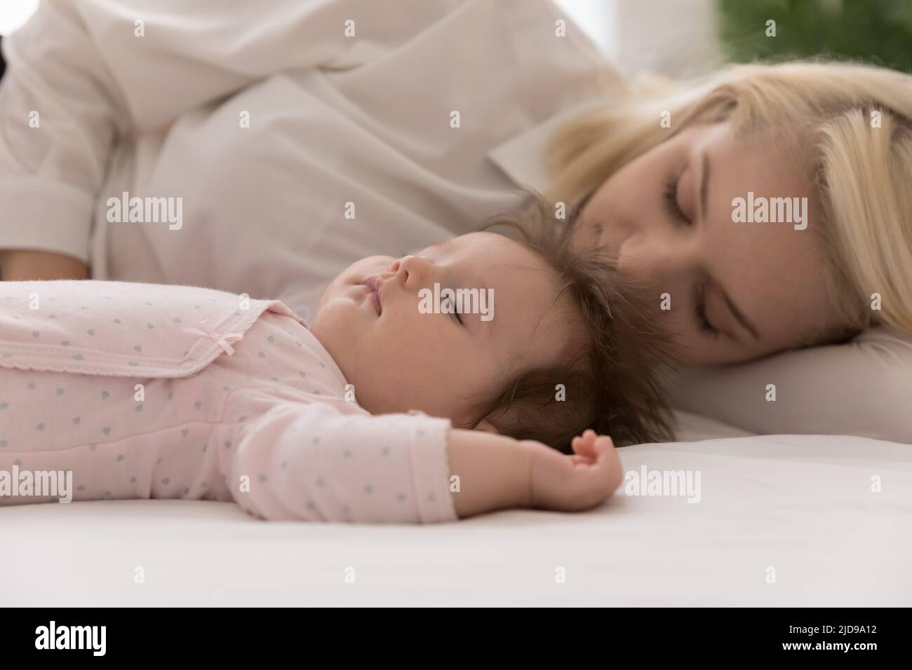 Close up shot peaceful baby and mother sleeping in bed Stock Photo
