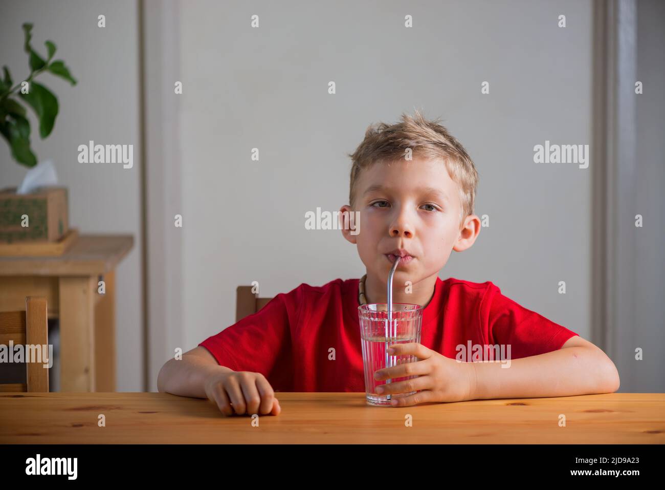 Handsome boy drinks water through drinking straw Stock Photo Alamy