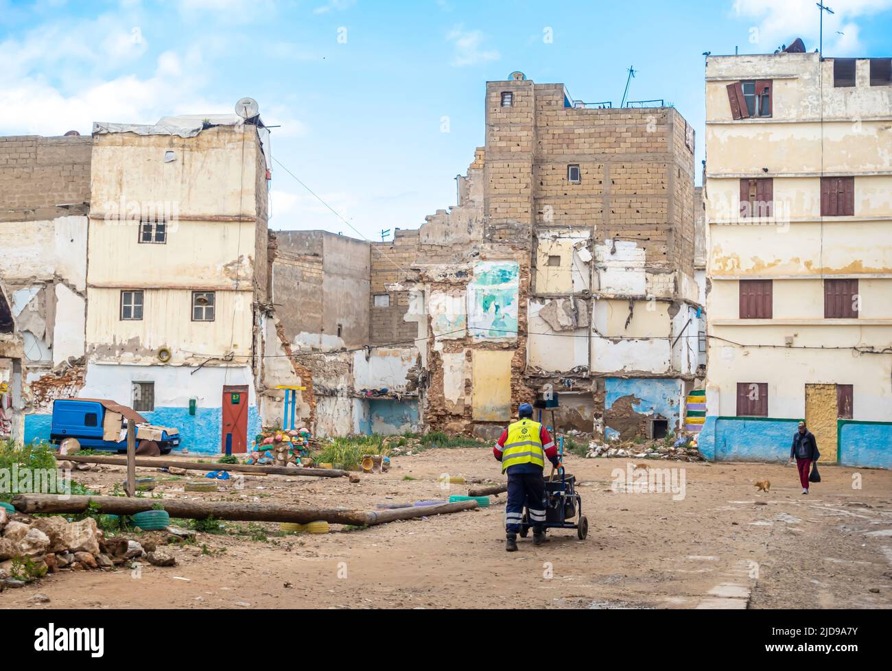 Serviceman pushing cart in the shabby yard inside neglected, undone, shabby residential blocks buildings in Bourgogne, Casablanca, Morocco Stock Photo