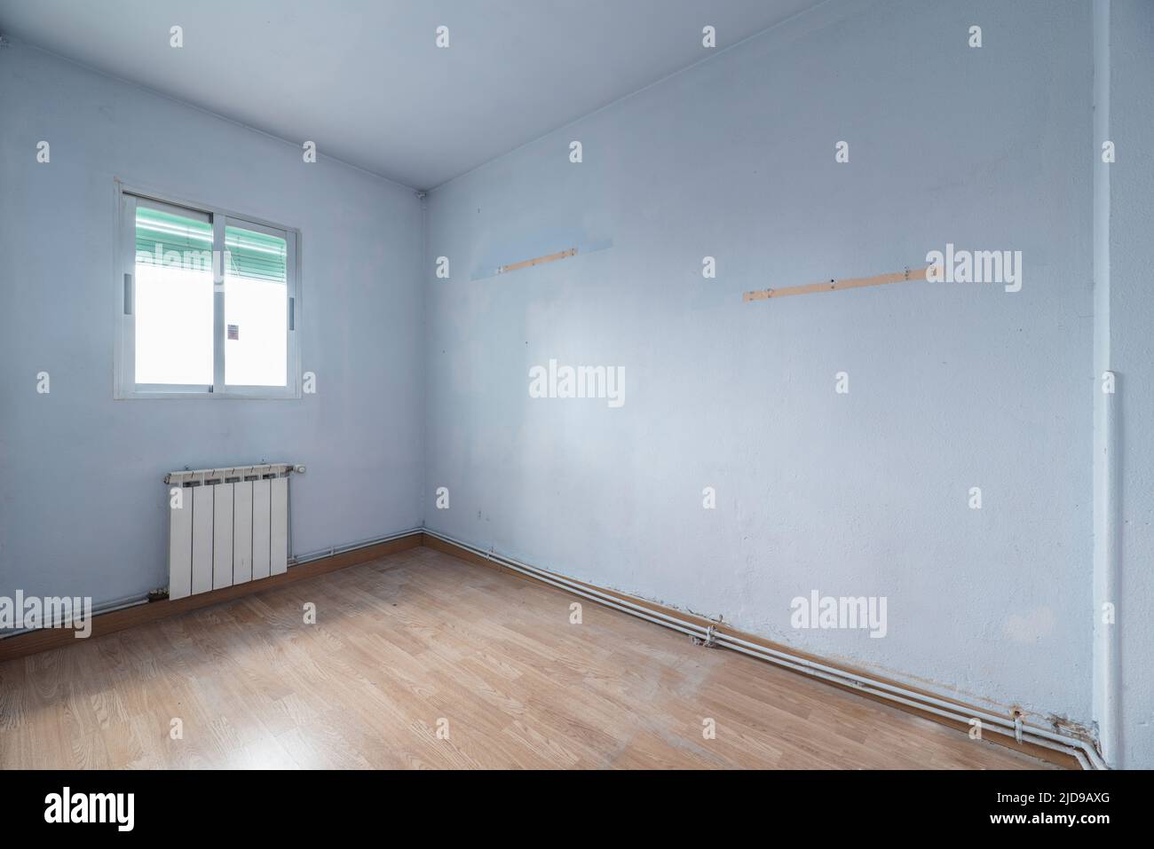 Empty room with oak flooring and blue painted walls Stock Photo