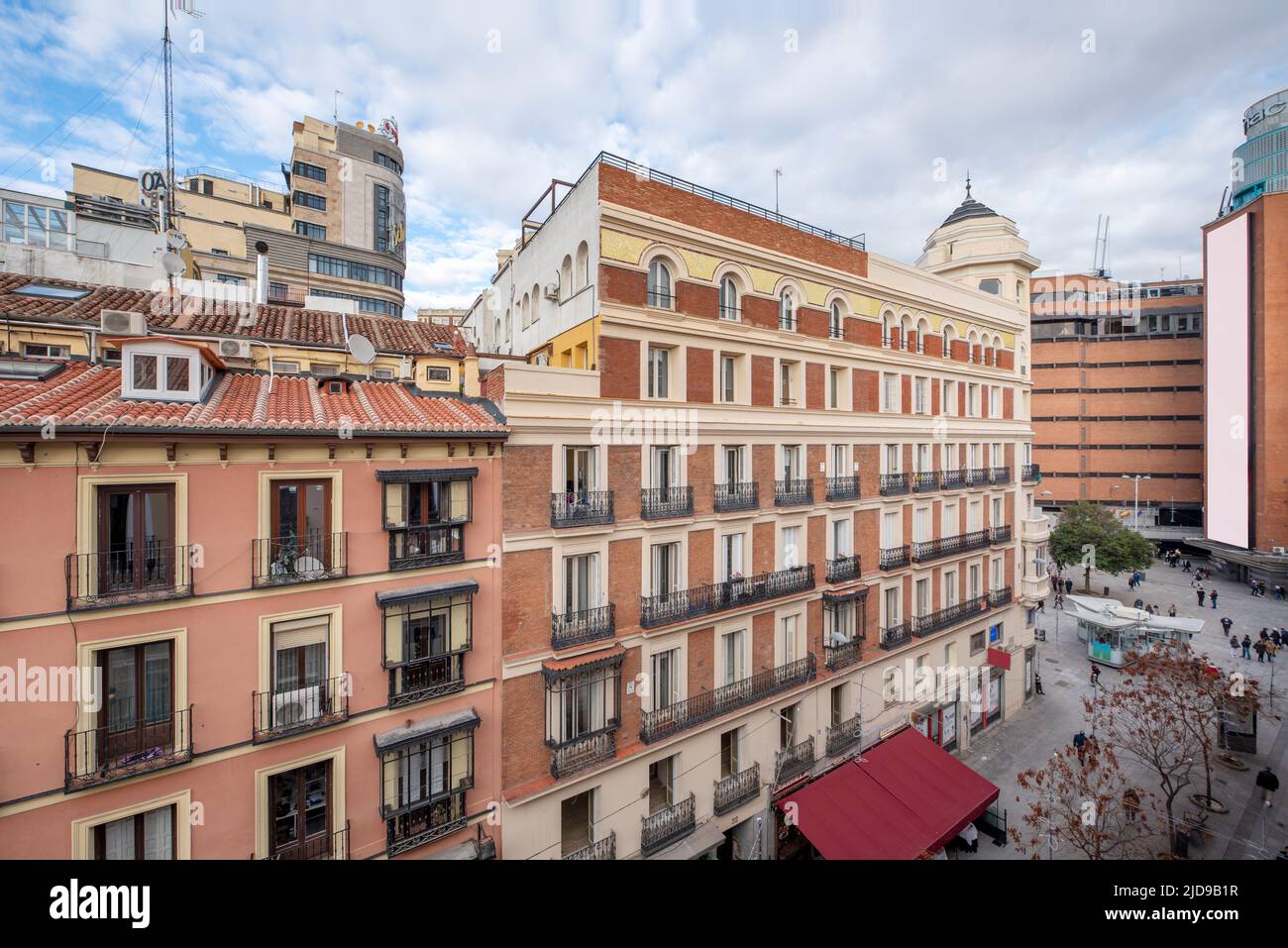 Facades of old urban residential buildings with clay roofs and small attic windows near Plaza del Callao in Madrid Stock Photo