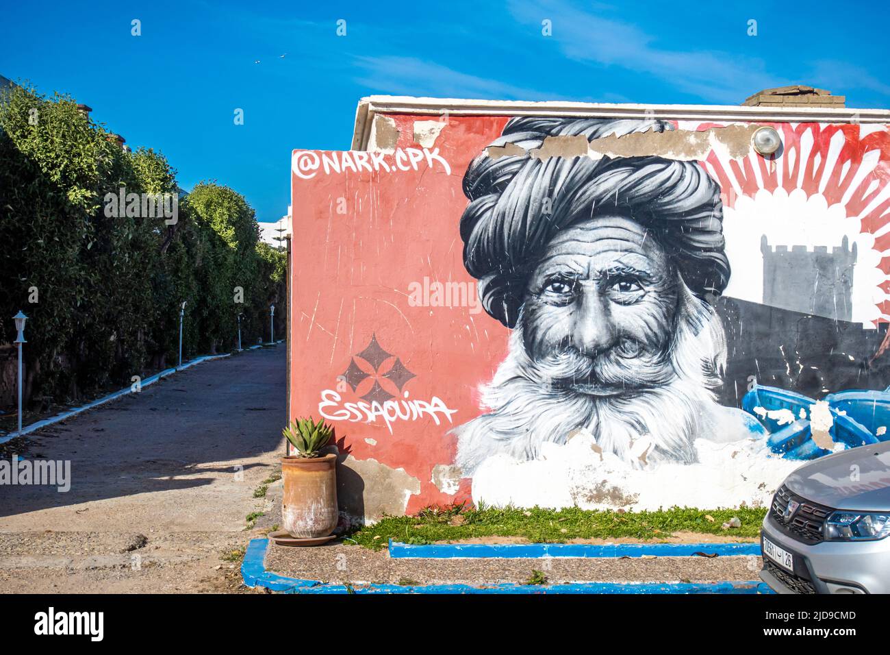 Street art, mural by artist @nark.cpk depicting beraded man in the port of Essaouira, Morocco Stock Photo