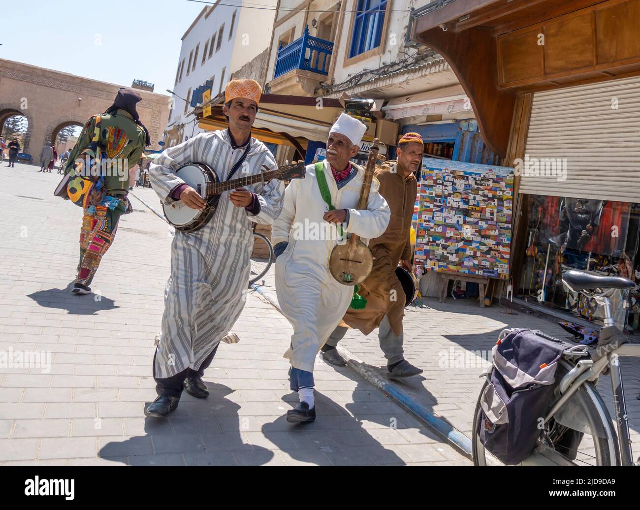 Two street performers musicians with Moroccan musical instrumets walking and playing in Medina, Essaouira, Morocco Stock Photo
