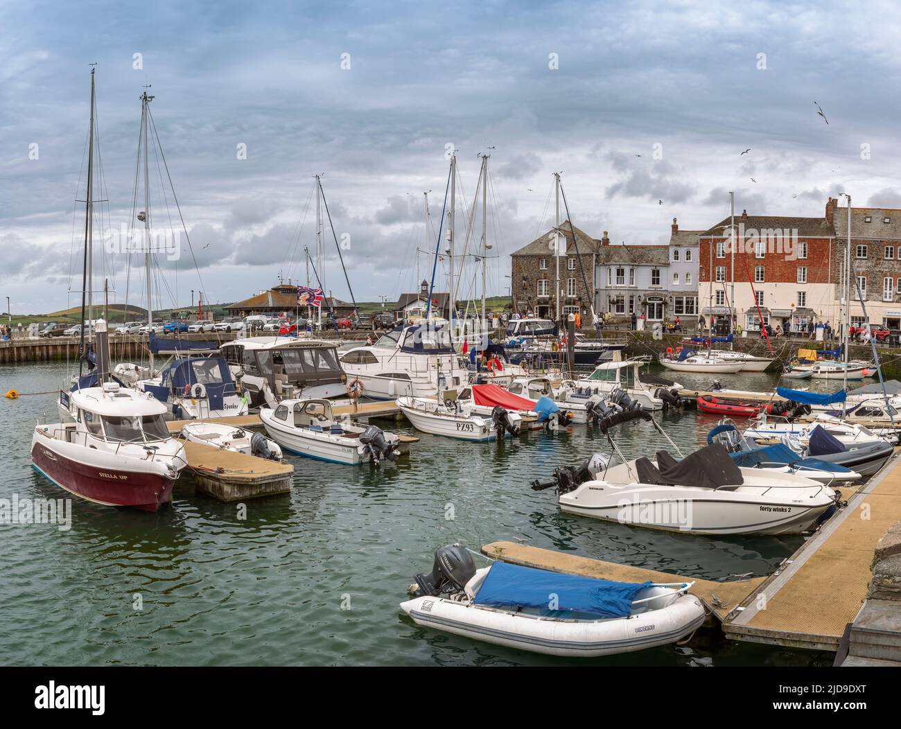 Padstow, Cornwall, England. Sunday 19th June 2022. A busy Sunday around the picturesque harbour of Padstow in Cornwall. Despite the overcast sky and ocaisional shower, visitors still flock to the popular Cornish fishing town, situated on the west bank of the River Camel estuary. Credit: Terry Mathews/Alamy Live News Stock Photo