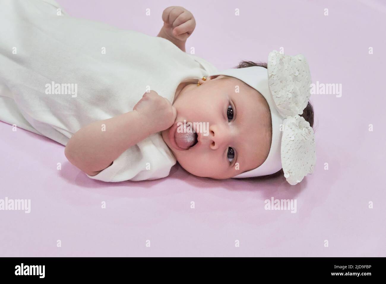 Baby Girl with white Flower Headband. 2-month-old baby girl. Stock Photo