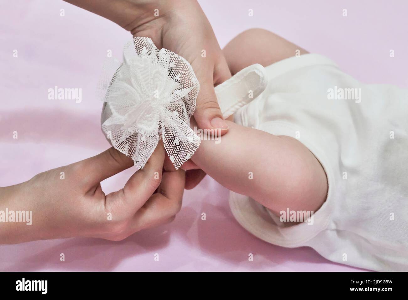 Close-up of cute little funny baby girl wearing a white booties Stock Photo