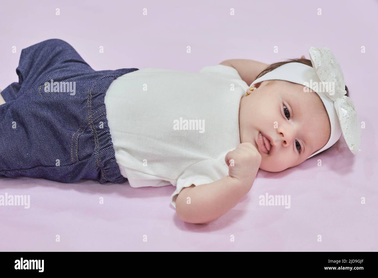 Baby Girl with white Flower Headband. 2-month-old baby girl. Stock Photo