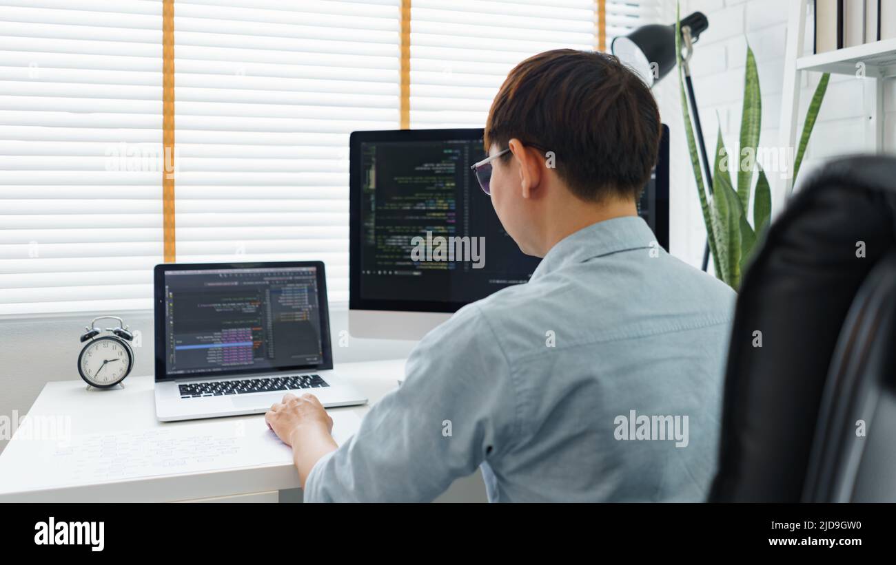 Software development concept, Male programmer typing data code on laptop to develop app and website. Stock Photo