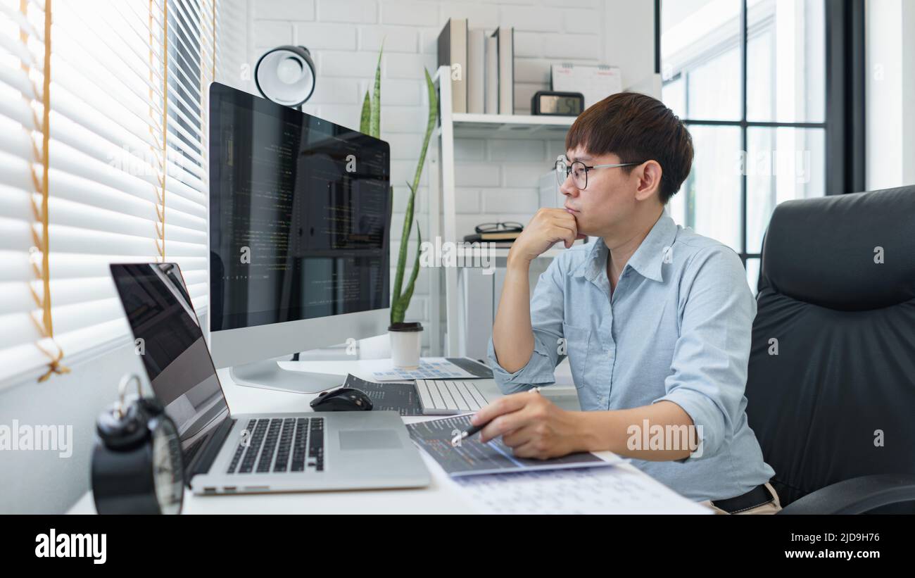 Software development concept, Male programmer read data code to thinking about developing website. Stock Photo