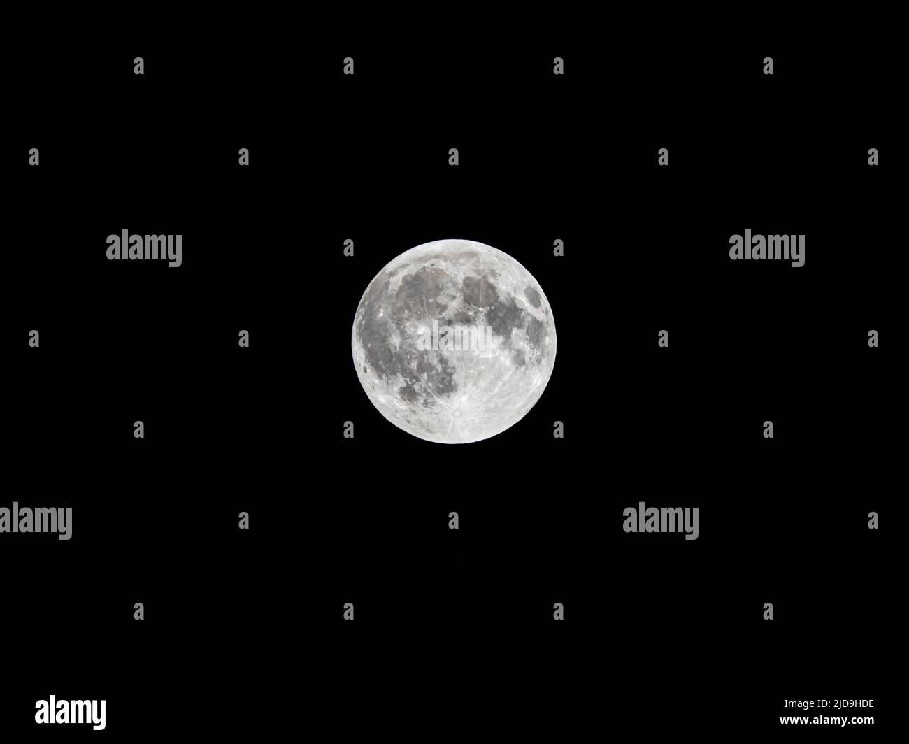 Full moon on black background. This surface texture is clearly visible from a location in middle Europe. The night sky is pitch black. Stock Photo