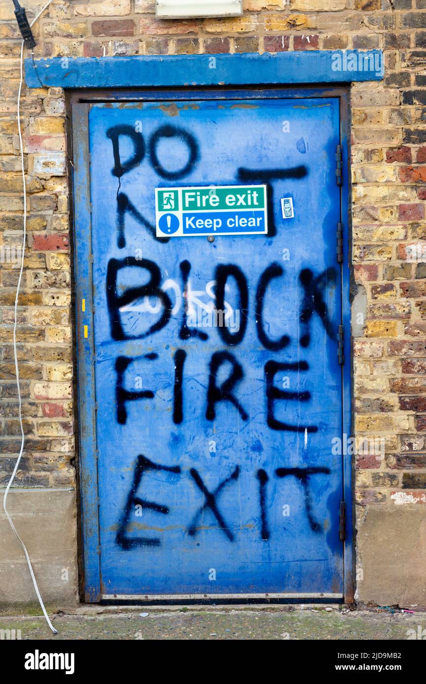 'Do Not Block Fire Exit', sign or art? Back street behind shops, Penge, SE London, UK. Stock Photo