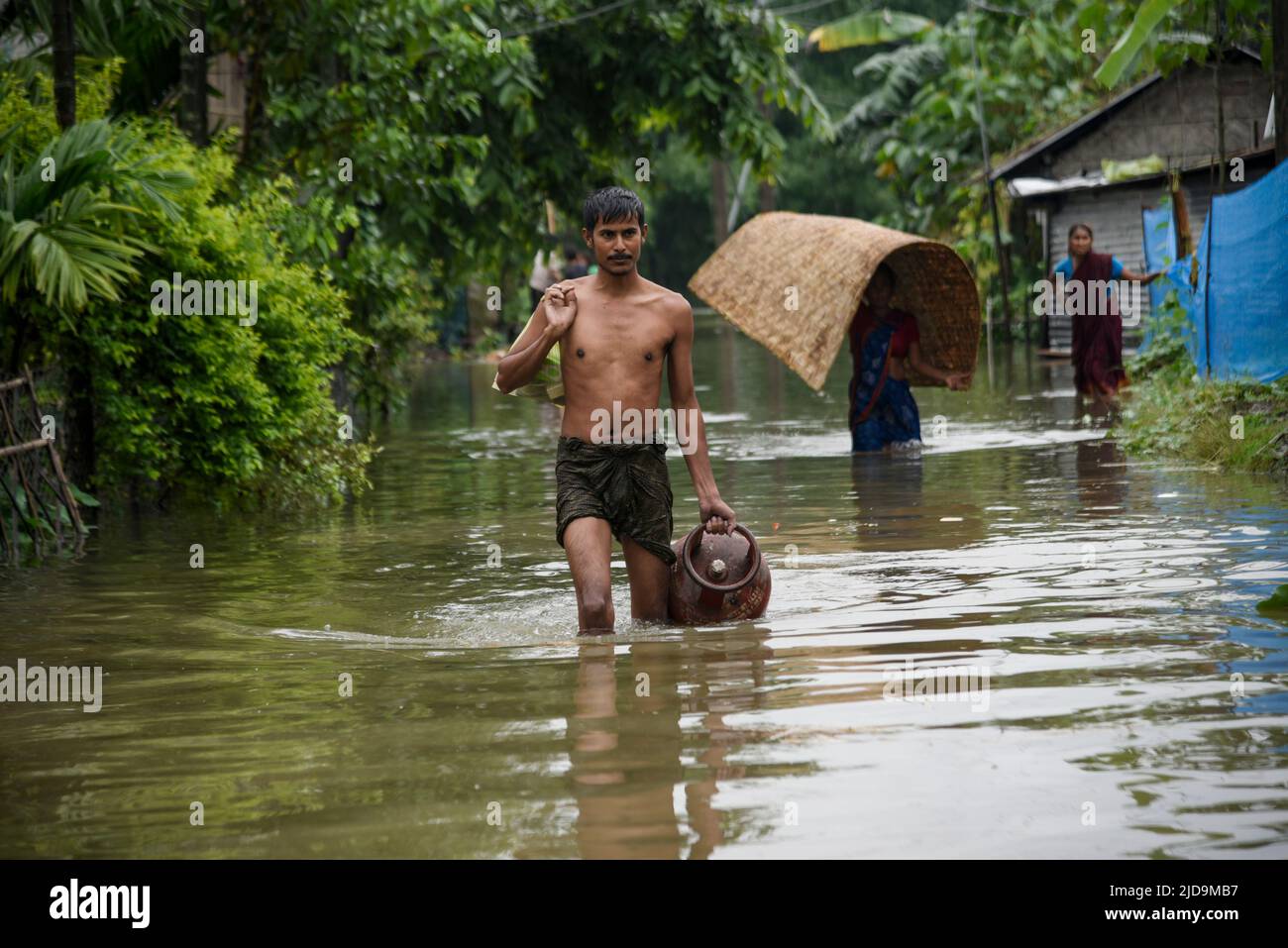 Flood affected people coming towards a safer place, at a village on June 17, 2022 in Barpeta, India. Assam flood situation deteriorates due to heavy rain,  millions of  people affected. Stock Photo