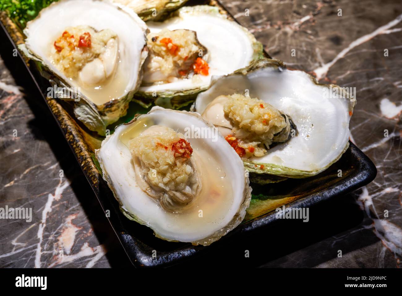 A delicious Japanese dish, steamed oysters with garlic Stock Photo Alamy