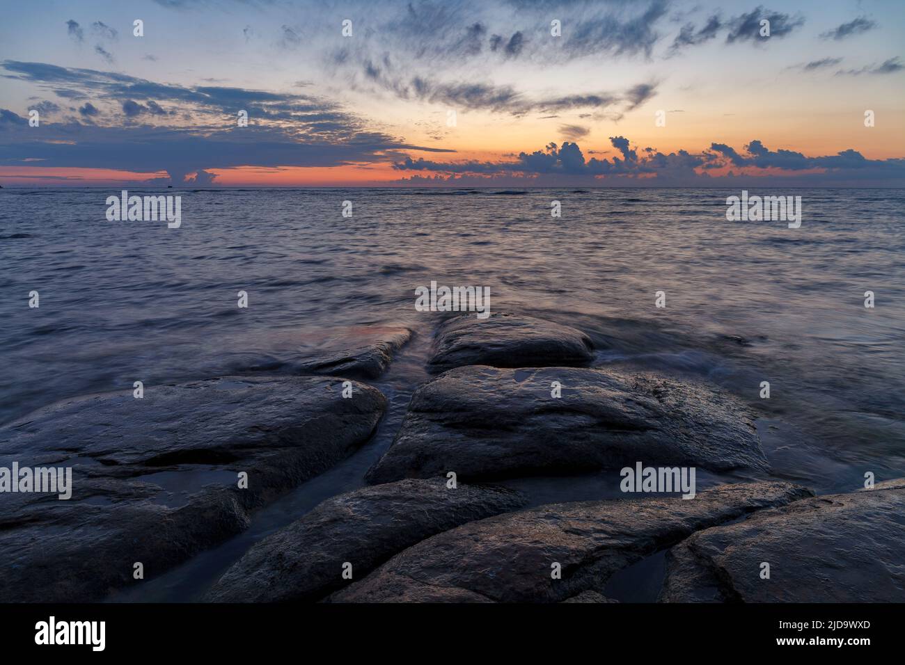 Boulders and rocks in the surf on coast of the Baltic sea at sunset