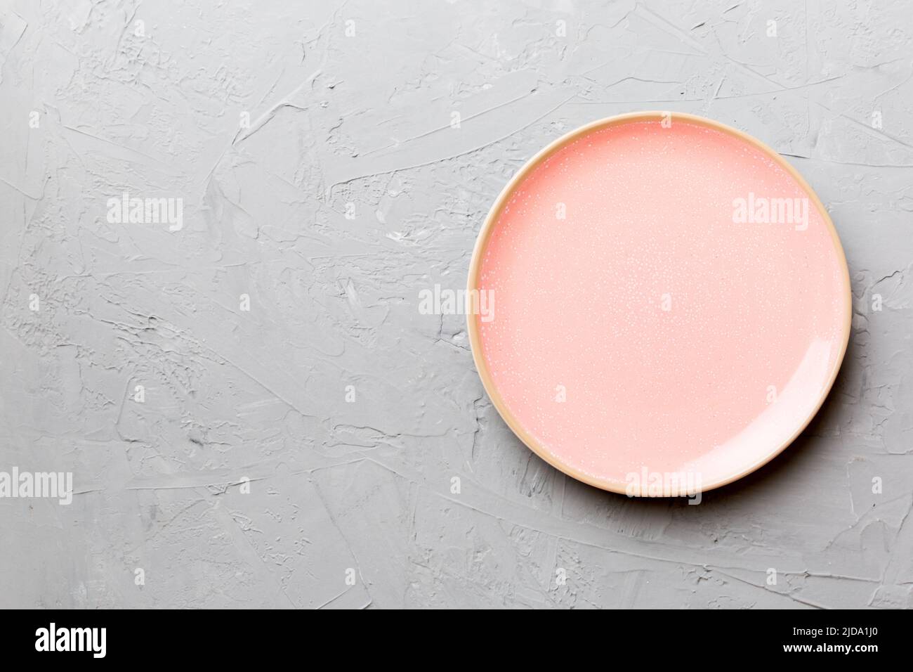 Top view of empty pink plate on cement background. Empty space for your ...