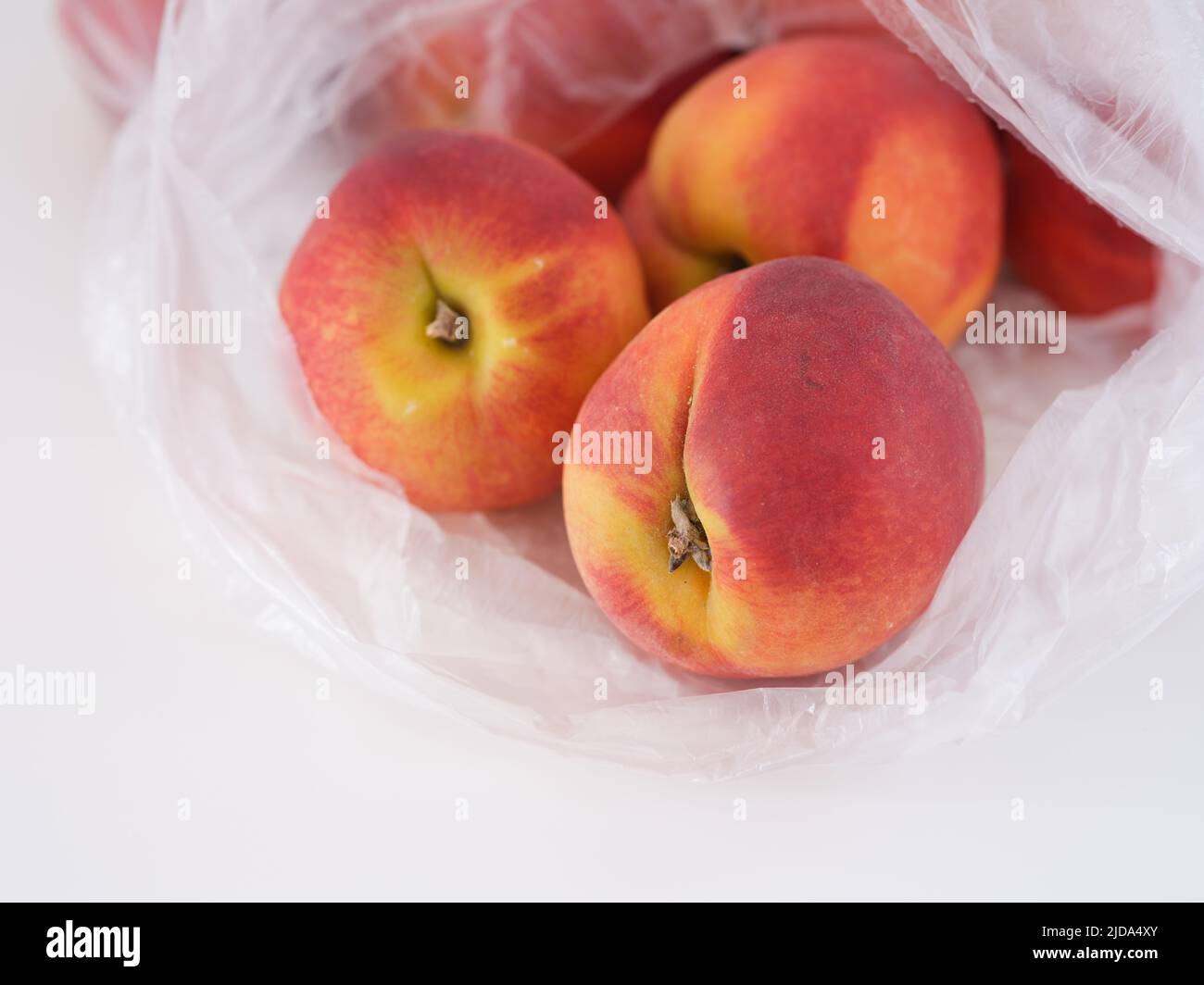 Freshly harvested peaches in a plastic bag. Close up. Stock Photo