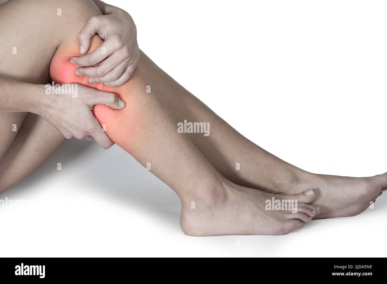 Calf muscle pain with hands covering it. Close-up Stock Photo