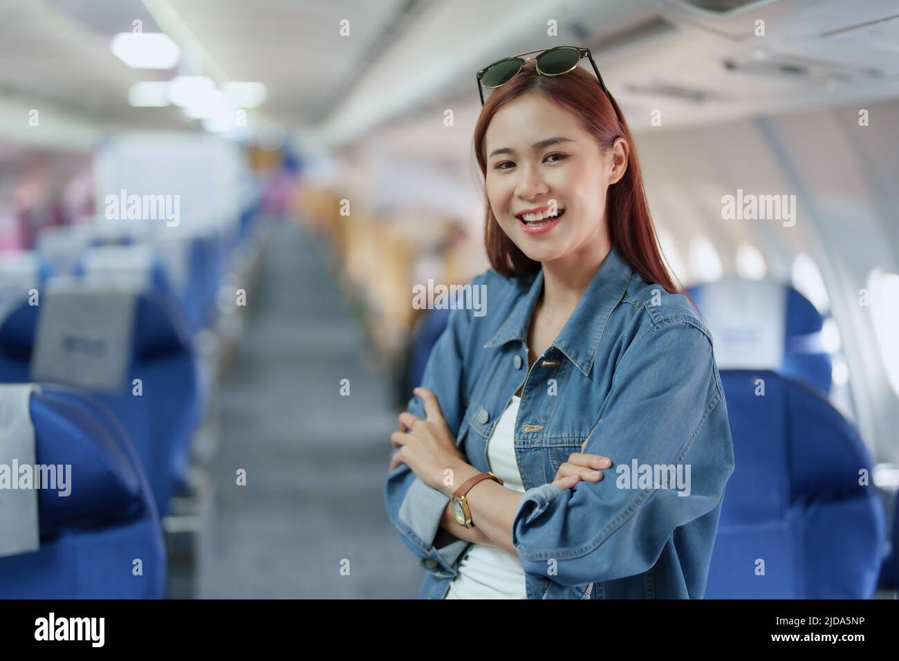 travel business Portrait of an Asian woman showing joy while waiting for a flight Stock Photo