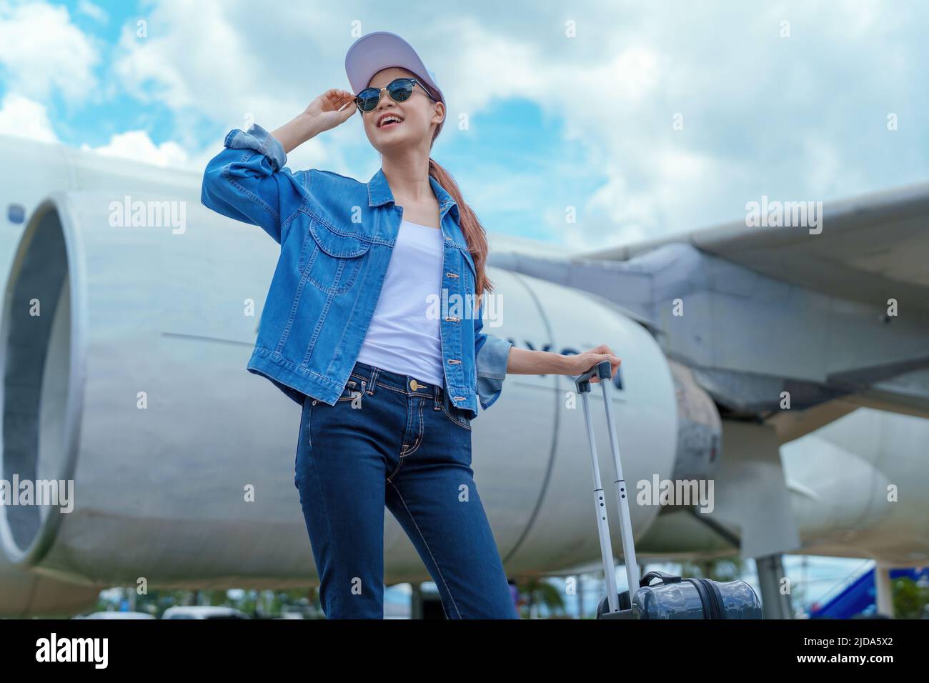 travel business Portrait of an Asian woman showing joy while waiting for a flight Stock Photo