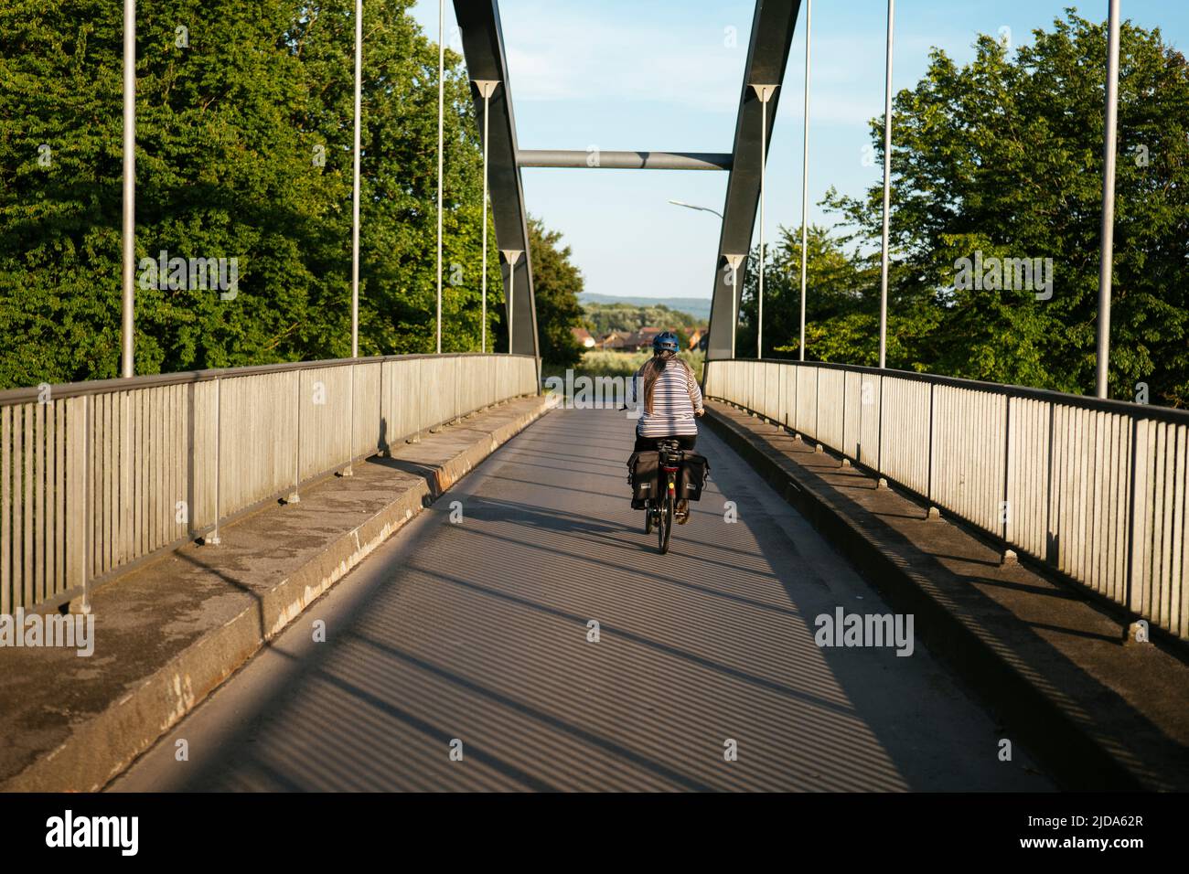 Woman on an e-bike crossing the midland canal near Bückeburg on a bridge. Stock Photo