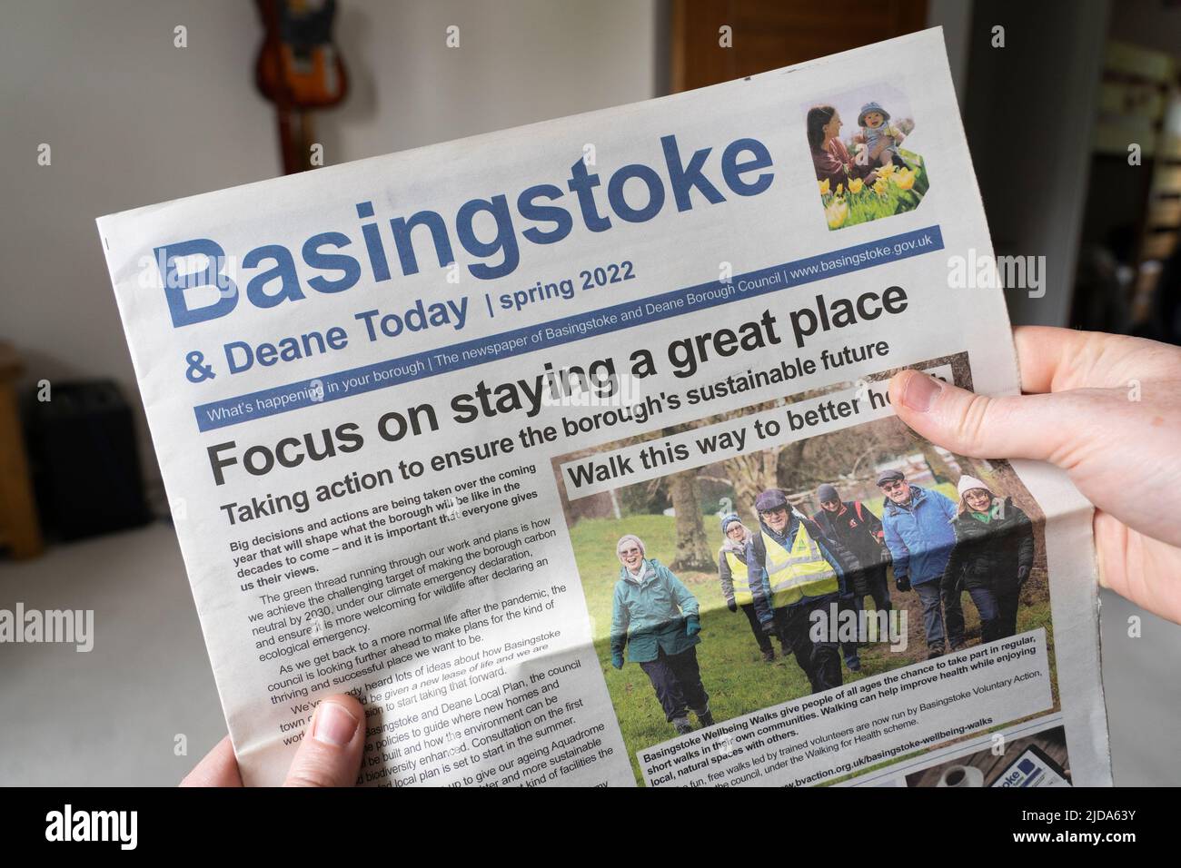 A man reading the front cover of Basingstoke and Deane Today local newspaper from Spring 2022. A local town UK newspaper / gazette Stock Photo