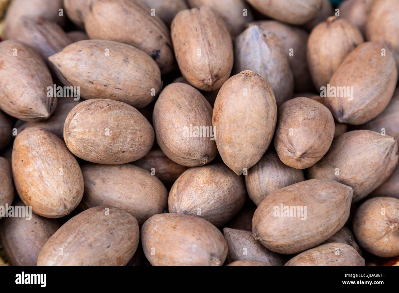 Looking down at whole pecan nuts for sale on a market stall Stock Photo