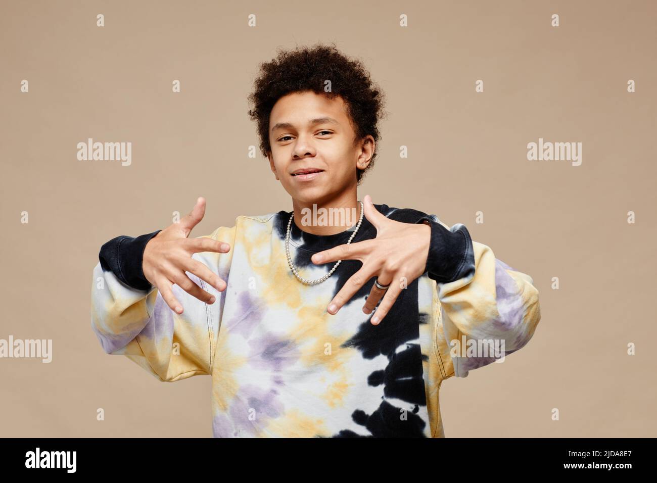 Waist up portrait of black teenage boy wearing tie dye shirt over