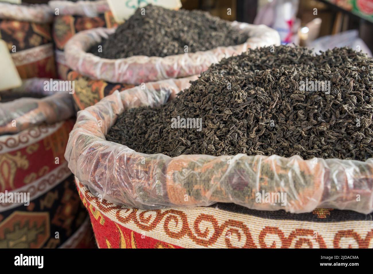 Black tea dried leaves in the colorful sacks on the traditional Turkish market close-up Stock Photo